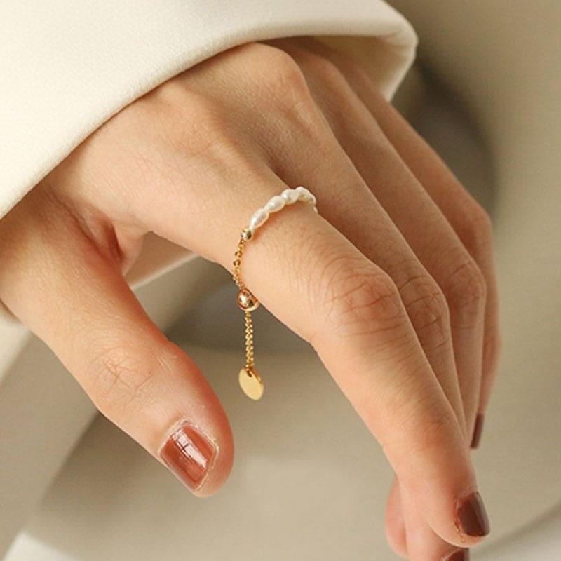 Elegant adjustable chain ring with gold alloy and delicate white pearls. Versatile and timeless, perfect for casual and evening wear.