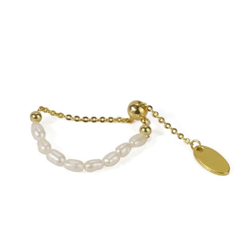 Elegant adjustable chain ring with gold alloy and delicate white pearls. Versatile and timeless, perfect for casual and evening wear.