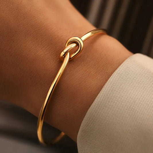 Elegant stainless steel knot bracelet in gold or silver. Adjustable cuff design for a perfect fit, symbolizing strength and unity. Tarnish-resistant and perfect for everyday wear.