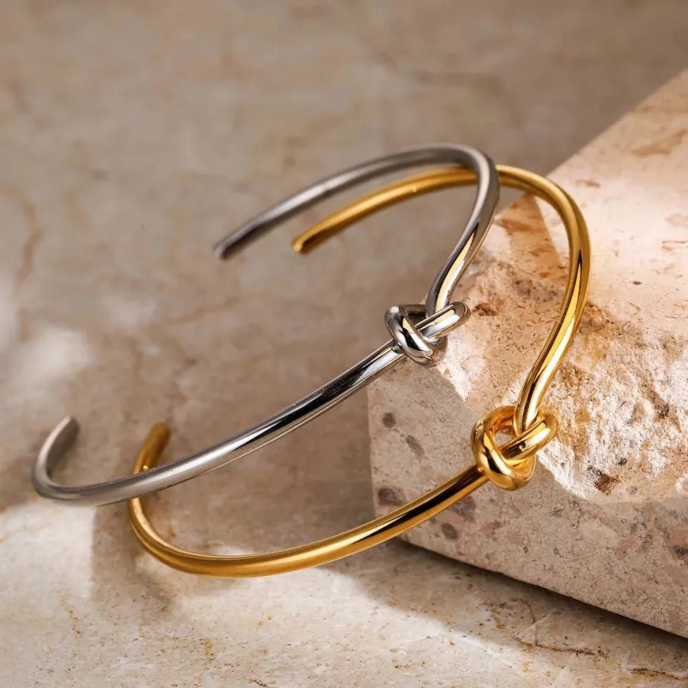 Elegant stainless steel knot bracelet in gold or silver. Adjustable cuff design for a perfect fit, symbolizing strength and unity. Tarnish-resistant and perfect for everyday wear.