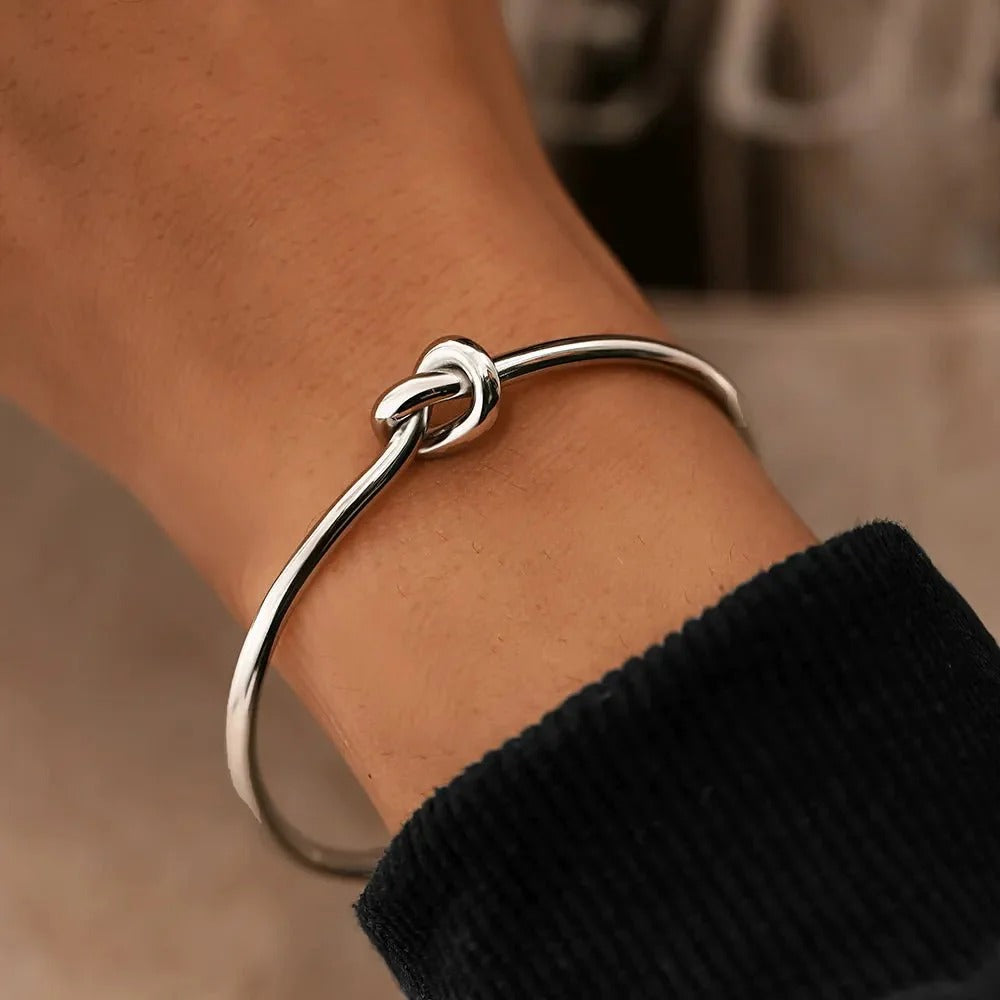 Elegant stainless steel knot bracelet in gold or silver. Adjustable cuff design for a perfect fit, symbolizing strength and unity. Tarnish-resistant and perfect for everyday wear.