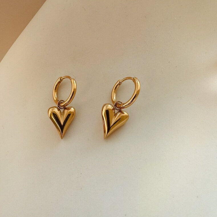 Elegant gold heart hoop earrings in 18K gold-plated stainless steel. Lightweight, hypoallergenic, and perfect for everyday wear or bridal elegance.