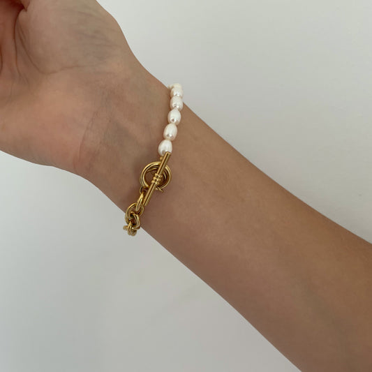 Elegant gold-plated link chain bracelet with perfectly round freshwater pearls. Features a toggle clasp, durable stainless steel, and a timeless design for everyday luxury.