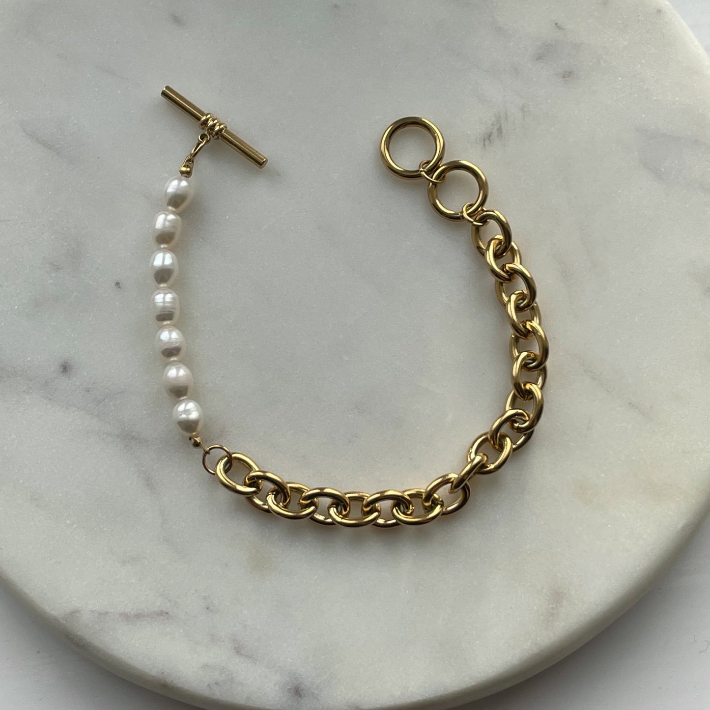 Elegant gold-plated link chain bracelet with perfectly round freshwater pearls. Features a toggle clasp, durable stainless steel, and a timeless design for everyday luxury.